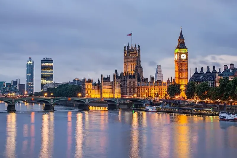 Parlamenti britanik dhe Big Ben-i në Londër, të ndriçuar në mbrëmje buzë lumit Thames